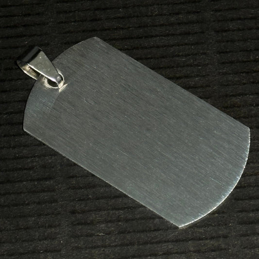 Metallic dog tag on a textured black background